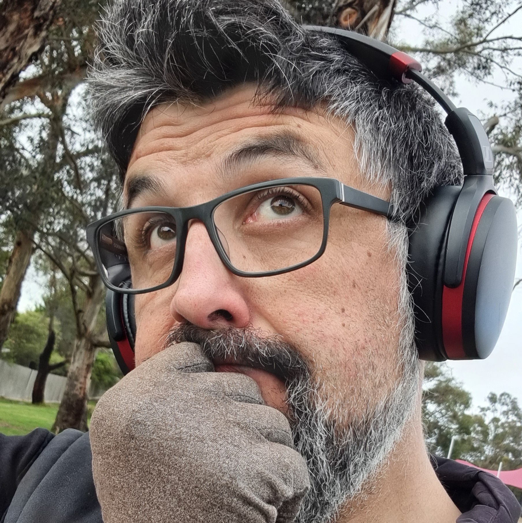 A photograph of Rob Norris, wearing glasses and headphones.